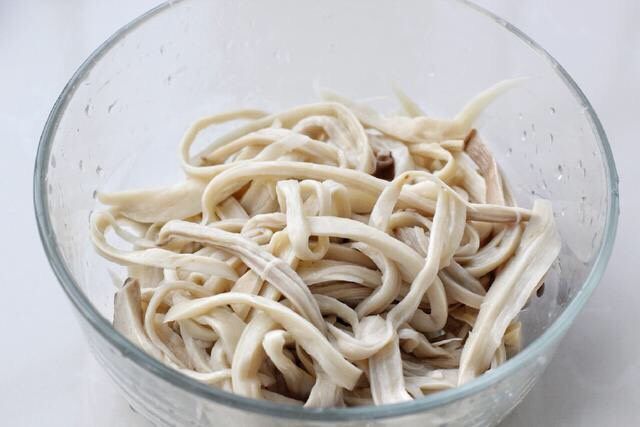 凉拌杏鲍菇,这时杏鲍菇也差不多蒸好了,取出晾凉后撕成小条放入容器中。或者直接用冷水冲洗的方式让杏鲍菇降温,这样比较节省时间。