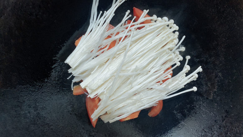 番茄鲈鱼,加入番茄块、金针菇,翻炒均匀