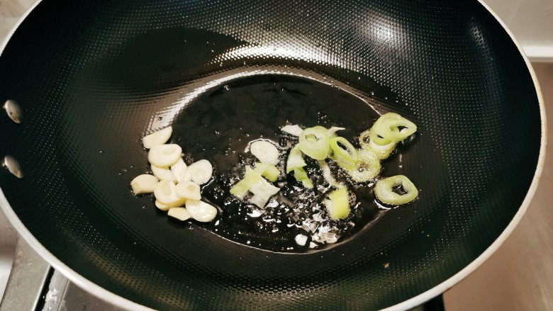 芹菜炒鱿鱼,起油锅放入食用油,油热后放入蒜片葱片炒出香味。