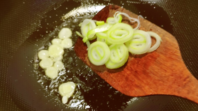 清炒油麦菜,起油锅放入食用油,油热后放入蒜片、葱片翻炒出香味。