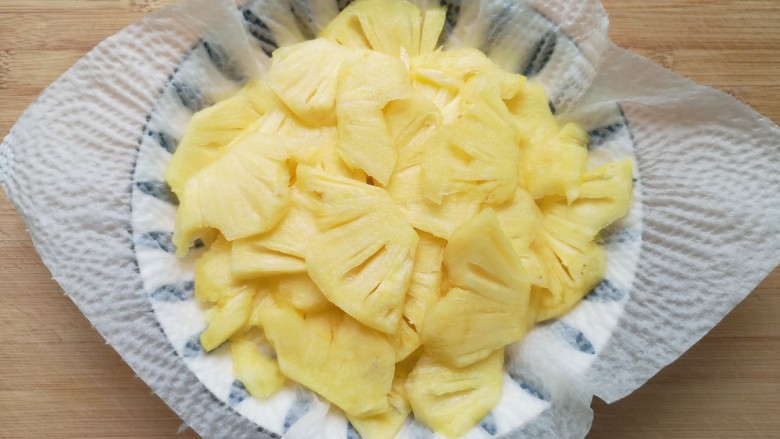 菠萝披萨,盘子里铺上厨房用纸,放上菠萝片吸一下多余的水分。