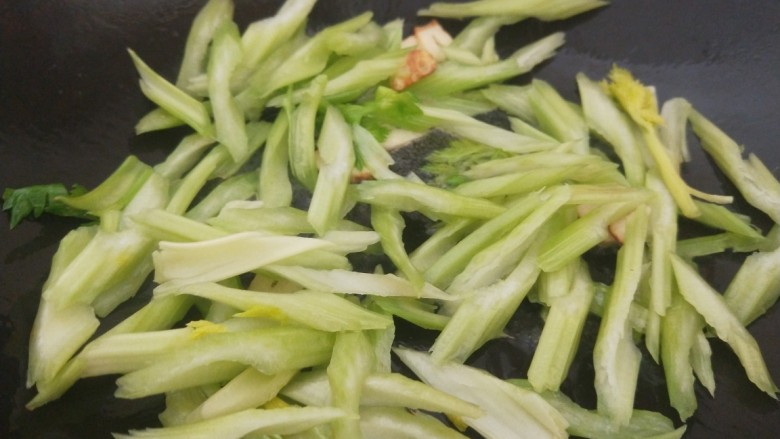 芹菜炒鱿鱼,倒入芹菜炒均匀。