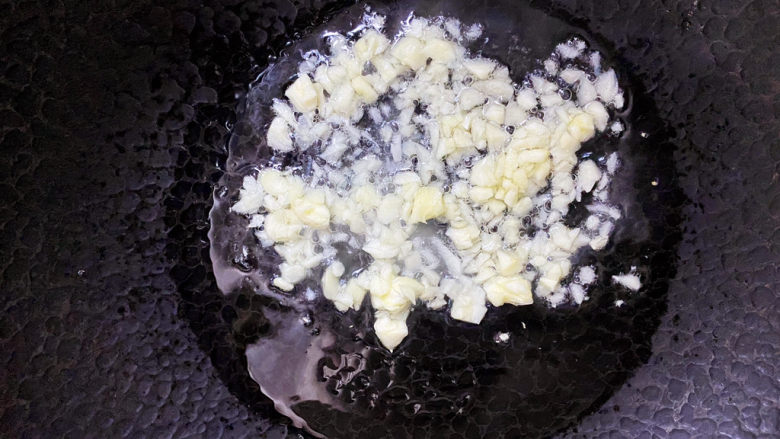 清炒油麦菜,锅里倒油烧热放入蒜炒香。