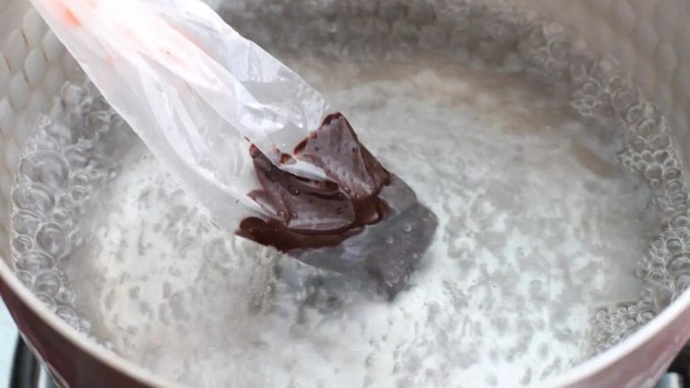棉花糖饼干,将适量黑巧克力放进裱花袋里,隔水加热至融化状态。