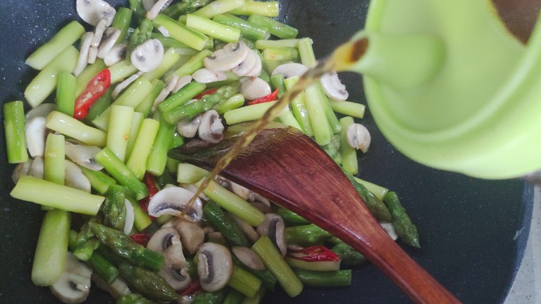 芦笋炒蘑菇,加适量料酒，继续翻炒30秒