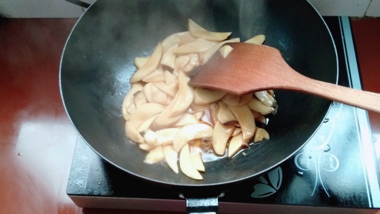 杏鲍菇炒肉片,加入盐,酱油炒匀,盖上盖子把杏鲍菇煮熟