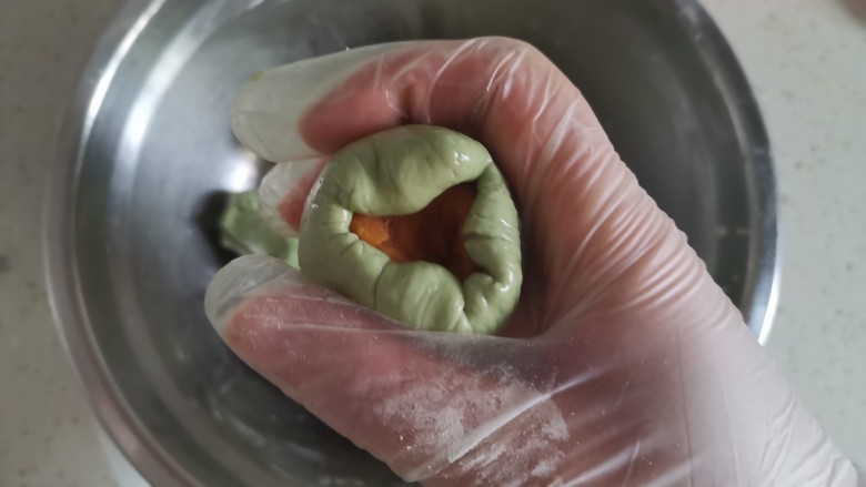 艾草青团,一手按住馅料,一手用虎口慢慢收紧