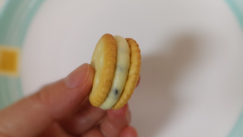 棉花糖饼干,盖上另外一片小奇福饼干,用手指轻轻摁一下,一个牛扎芝麻饼干就做好了。