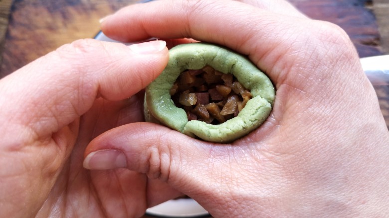 艾草青团,左手拖住,右手用虎口收口。
