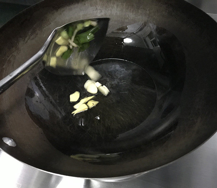 辣炒花甲,炒锅烧热,倒入食用油,下入姜蒜片爆香