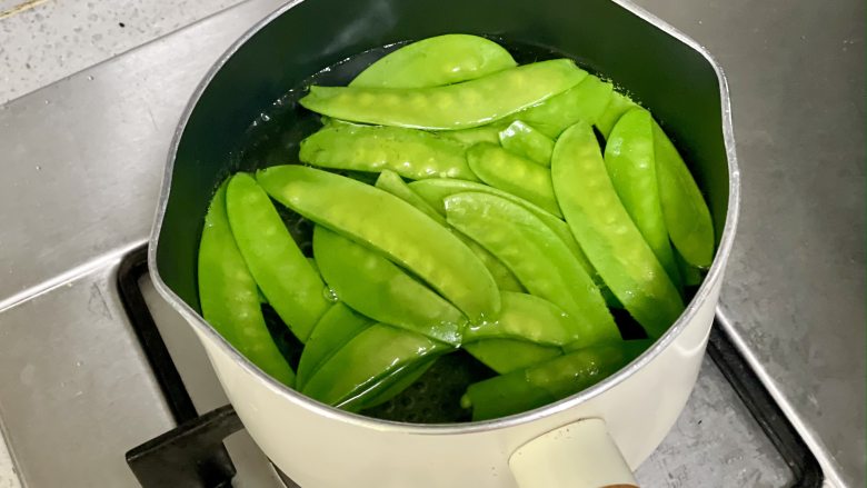 荷兰豆百合炒虾仁,低脂清爽,营养丰富,锅中烧开水,放一小勺盐和食用油,这样可以减少营养流失,下荷兰豆焯烫30秒。