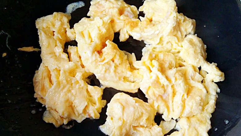 香椿炒蛋,放入的鸡蛋液迅速膨胀,但是中心部位还是液体,此时用铲子将边缘划开一道缝,待蛋液流出后,迅速用铲子从中心向四周打圈,鸡蛋全部变成固体后即可出锅装盘了。一次不要炒得太多,身手一定要敏捷,否则很容易炒老或炒糊。