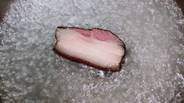 蒜苔回锅肉,锅中烧开水,放入腊肉煮8分钟。