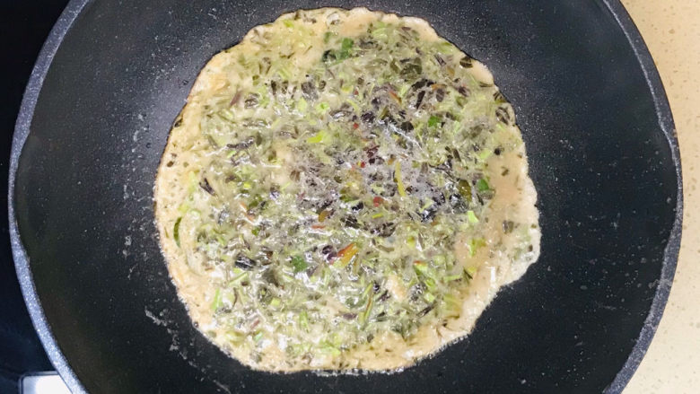 香椿炒蛋,转中火,先慢慢煎至香椿鸡蛋液硬固