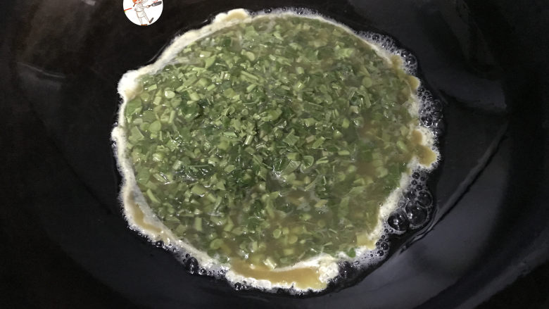 香椿炒蛋,把香椿鸡蛋液倒入锅中,用中火煎至蛋液凝固,翻面,继续
