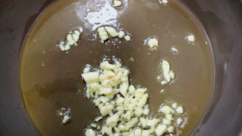 芦笋炒蘑菇,锅中倒入油,加热至五成热,爆香蒜末。