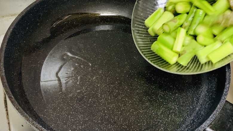 芦笋炒蘑菇,油热后,倒入芦笋。