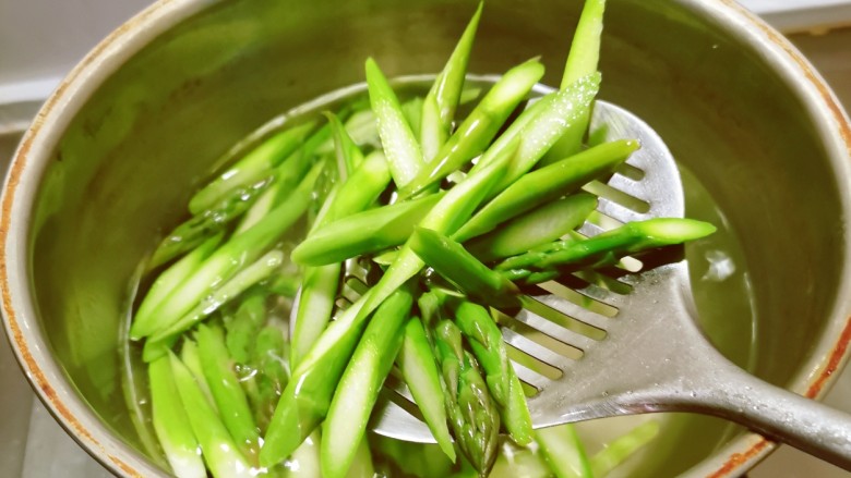 芦笋炒蘑菇,放入开水中汆烫断生捞出,水中加入2克盐和几滴食用油,保持芦笋的翠绿颜色。