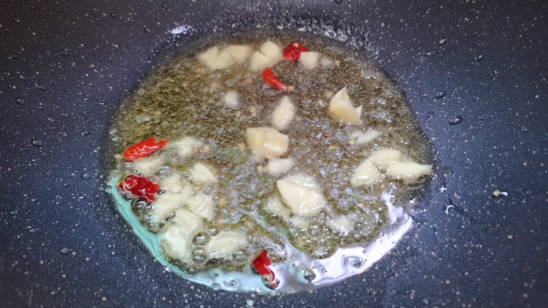 芦笋炒蘑菇,油锅加热后,蒜蓉,干辣椒煸香