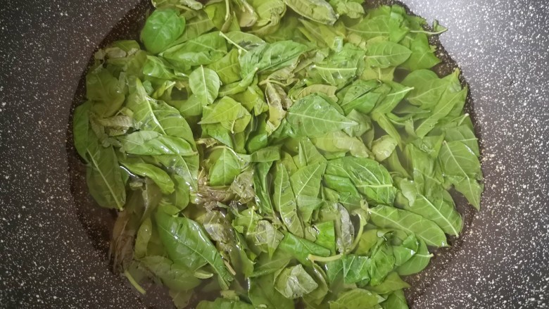 香椿炒腊肉,锅里放水烧开,下入香椿叶焯水。