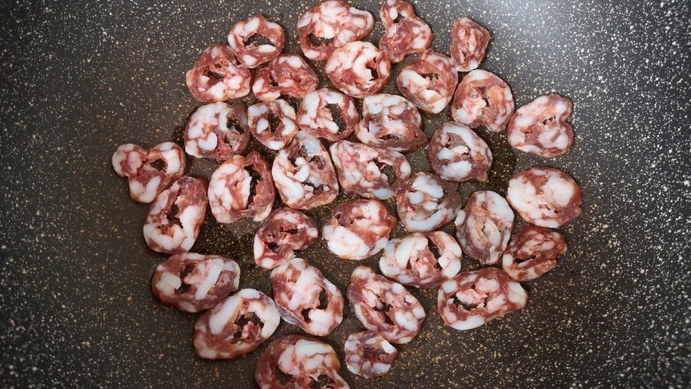 香椿炒腊肉,炒锅内倒适量食用油烧热,码入腊肠片。