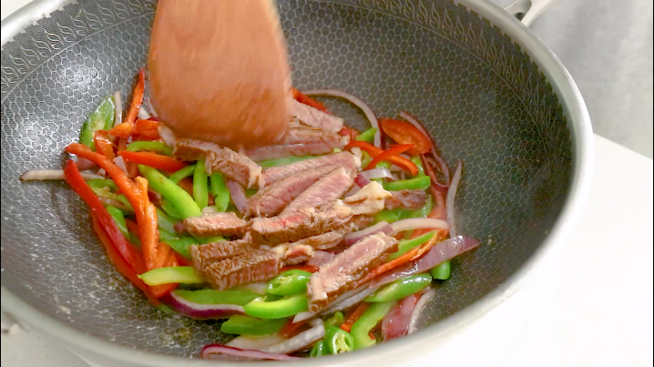黑椒牛肉意面,加入一勺盐调味,加入牛排条继续翻炒
