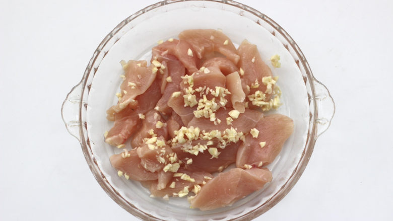 香煎孜然鸡块,把鸡块放入盘里,加入大蒜末。