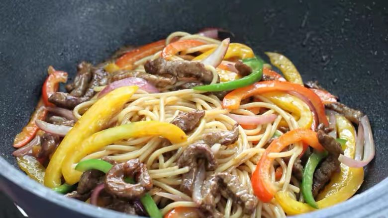 黑椒牛肉意面,沿着锅边淋入调味汁,快速翻炒均匀关火即可。