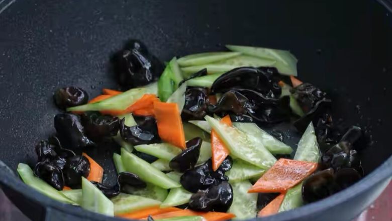 什锦虾仁,锅中倒适量食用油烧热,将木耳、黄瓜和胡萝卜一同放进锅中,大火快速翻炒一分钟左右,调入<a style='color:red;display:inline-block;' href='/shicai/ 721'>蚝油</a>和适量盐翻炒均匀。