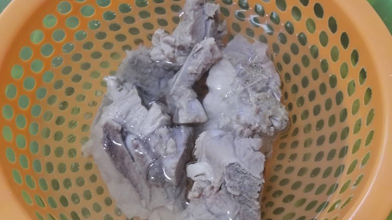 剑花猪骨汤,捞出,冲洗掉杂质,然后热油锅,加入猪骨和料酒炒炒1分钟