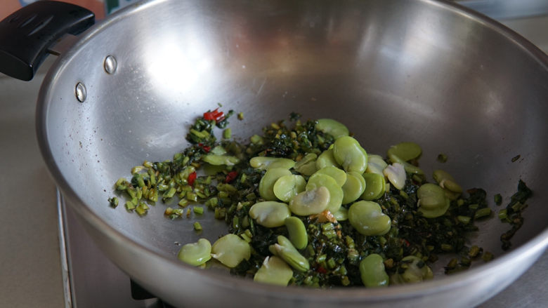 雪菜炒蚕豆,加入蚕豆,翻炒入味即可