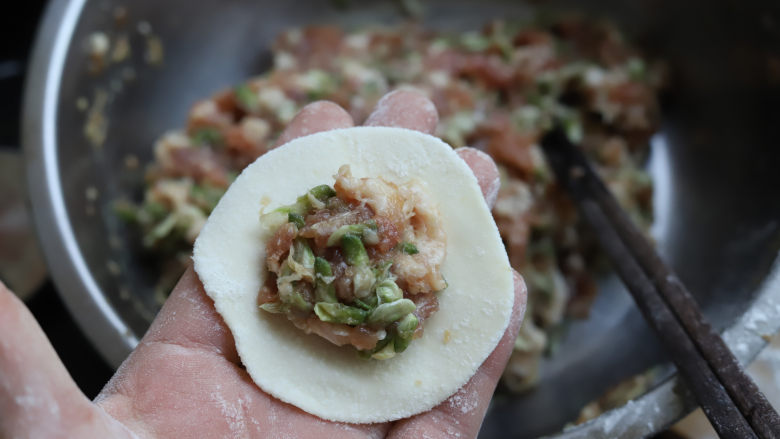 槐花饺子,包入适量的槐花肉馅，馅料不要太多也不要太少，紧着饺子皮的中间放，然后对折，捏紧收口就行。