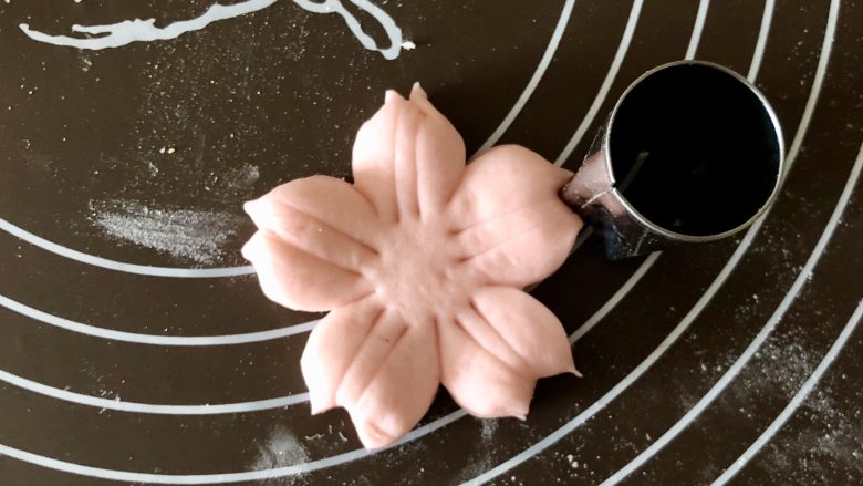 舍不得入口的樱花馒头,美美地开放在餐桌上,再用五角星模具在花瓣顶端切一下,切出一个和樱花花瓣一样的小缺口,这样更有樱花的感觉。