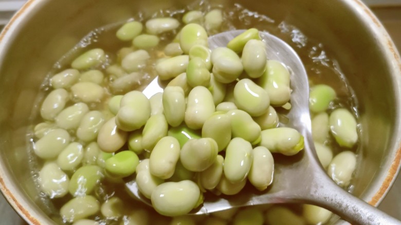韭菜炒蚕豆,蚕豆去掉外壳,放入开水中煮3分钟,水中加入2克盐和几滴食用油。