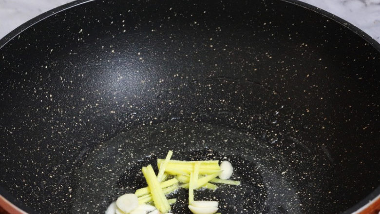 葱爆牛肉,锅中倒入适量的食用油烧热,放入蒜末和姜丝炒出香味