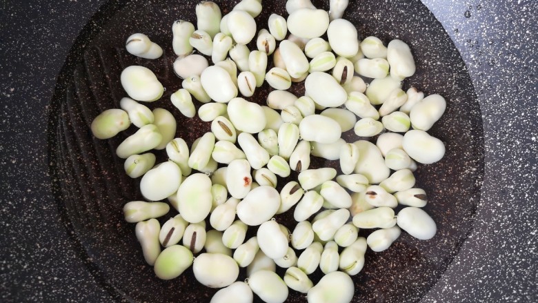 韭菜炒蚕豆,锅里放水烧开,下入蚕豆焯水2分钟。