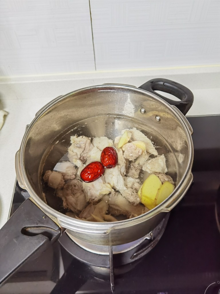 舌尖上的美味~松茸养生鸡汤,把鸡肉倒入锅中焯一遍水后,换一锅清水煮开后撇去浮末后加入红枣和姜片。