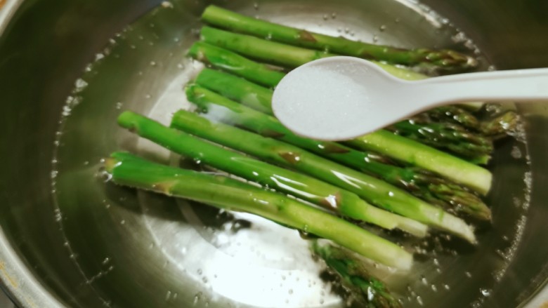 凉拌芦笋,放入开水中焯水断生,水中加入2克盐和几滴食用油。