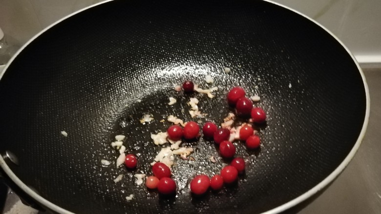 酸汤米线,起油锅放入食用油,油热后放入蒜末炒至微微焦黄色,放入蔓越莓果。