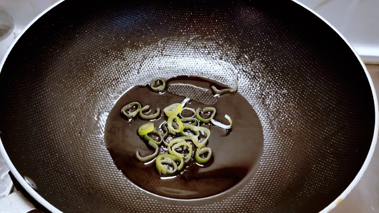 西红柿炖牛肉,起油锅放入食用油,油热后放入葱片炒出香味。