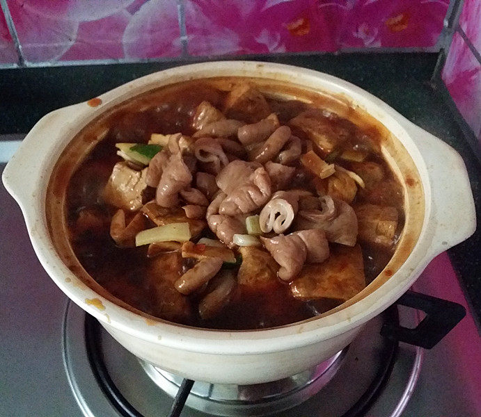 肥肠炖豆腐,和肥肠及葱姜蒜,一起倒入砂锅中,开盖,大火煮沸