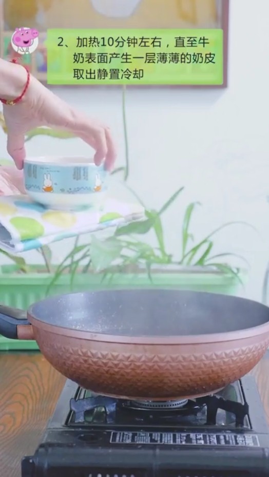 双皮奶,步骤二:加热10分钟左右,直至牛奶表面产生一层薄薄的奶皮取出静置冷却。