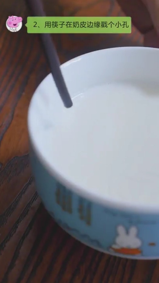 双皮奶,步骤四:用筷子在奶皮边缘戳个小孔。