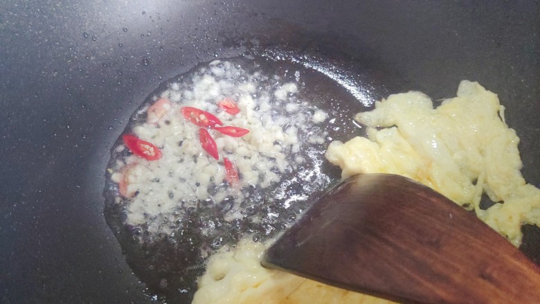 素炒平菇,鸡蛋翻炒凝固结块之后拨到一边,下大蒜末和小米椒,煸香