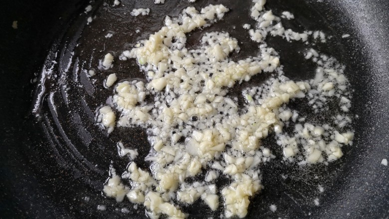 金针菇豆腐煲,锅中留适量底油,下入蒜末炒至微黄,炒出蒜香。
