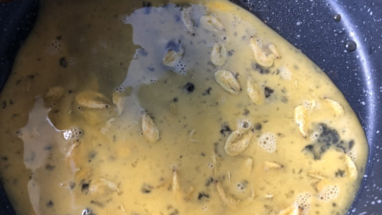 蚕豆炒鸡蛋,倒入鸡蛋液,等凝固后划散蛋块。