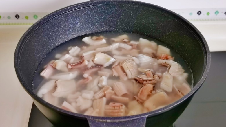蒜苔炒鱿鱼,锅中水烧开下鱿鱼,大火烧开煮2分钟捞出沥干水分。