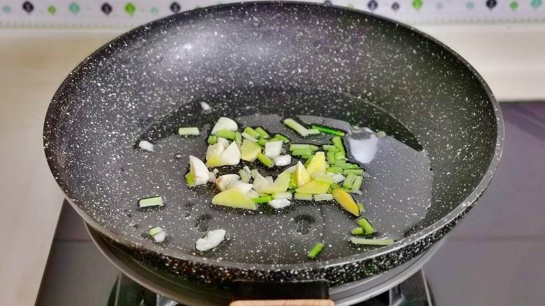 韭菜炒鱿鱼,起油锅加入切好的葱姜蒜,煸炒出香味儿。