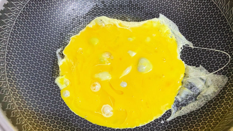 平菇鸡蛋汤,锅中倒入适量的食用油烧热,倒入蛋液,用筷子快速搅碎