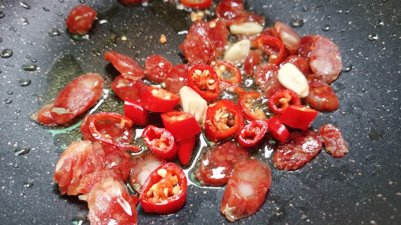 西葫芦炒腊肠,红尖椒,蒜头放入煸炒